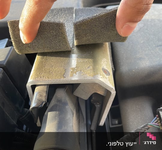 יד מחזיקה ספוג על חלק במנוע רכב